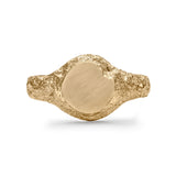 Gold signet ring showing eroded texture and matte circular face with chipped detail.