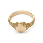 Gold signet ring showing inside view with eroded texture and matte circular face with chipped detail.