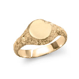 Gold signet ring showing inner polished band and exterior eroded texture.