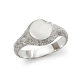 Small round textured silver signet ring showing polished inner band detail.