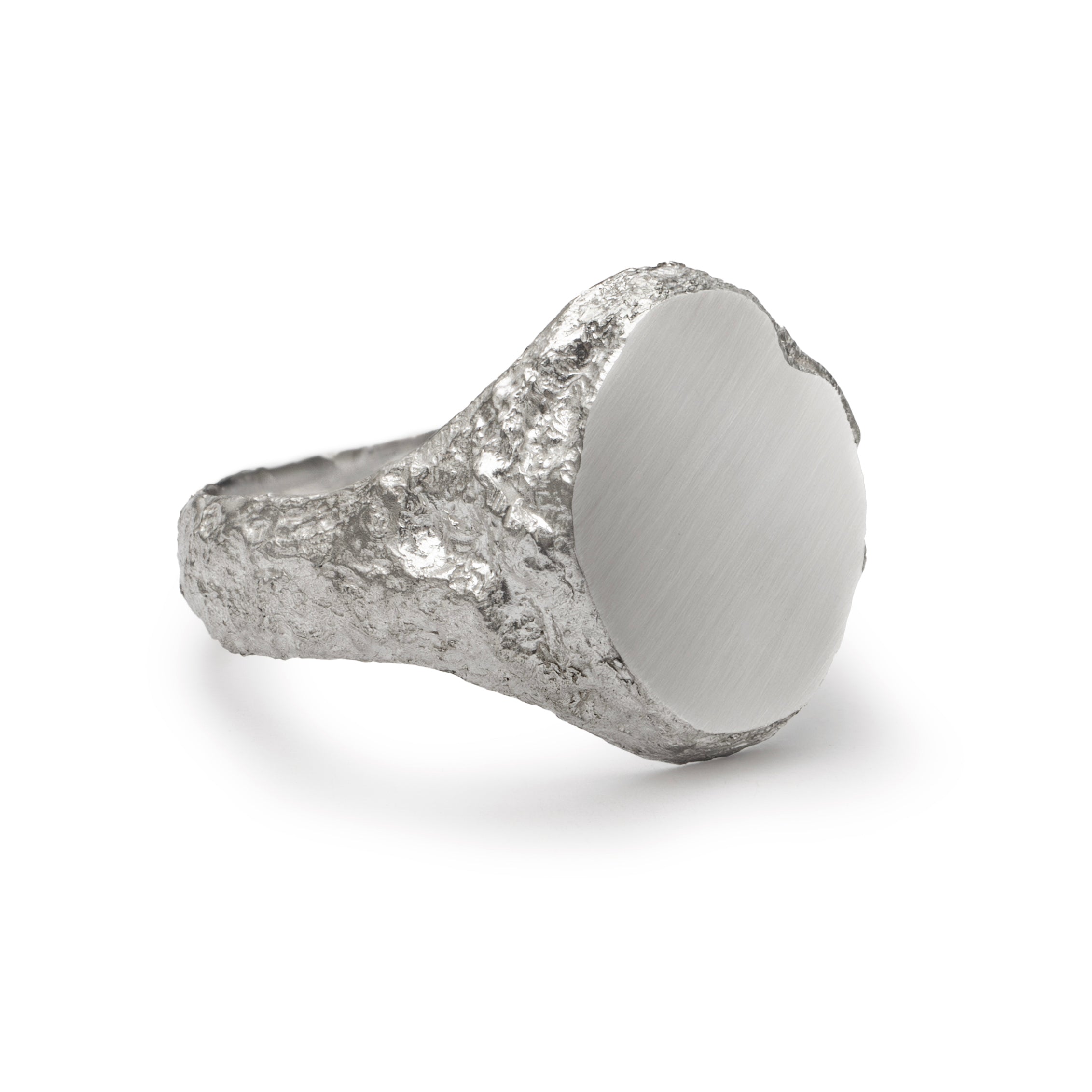 Side detail of signet ring in sterling silver with textured shoulders and chipped facade.
