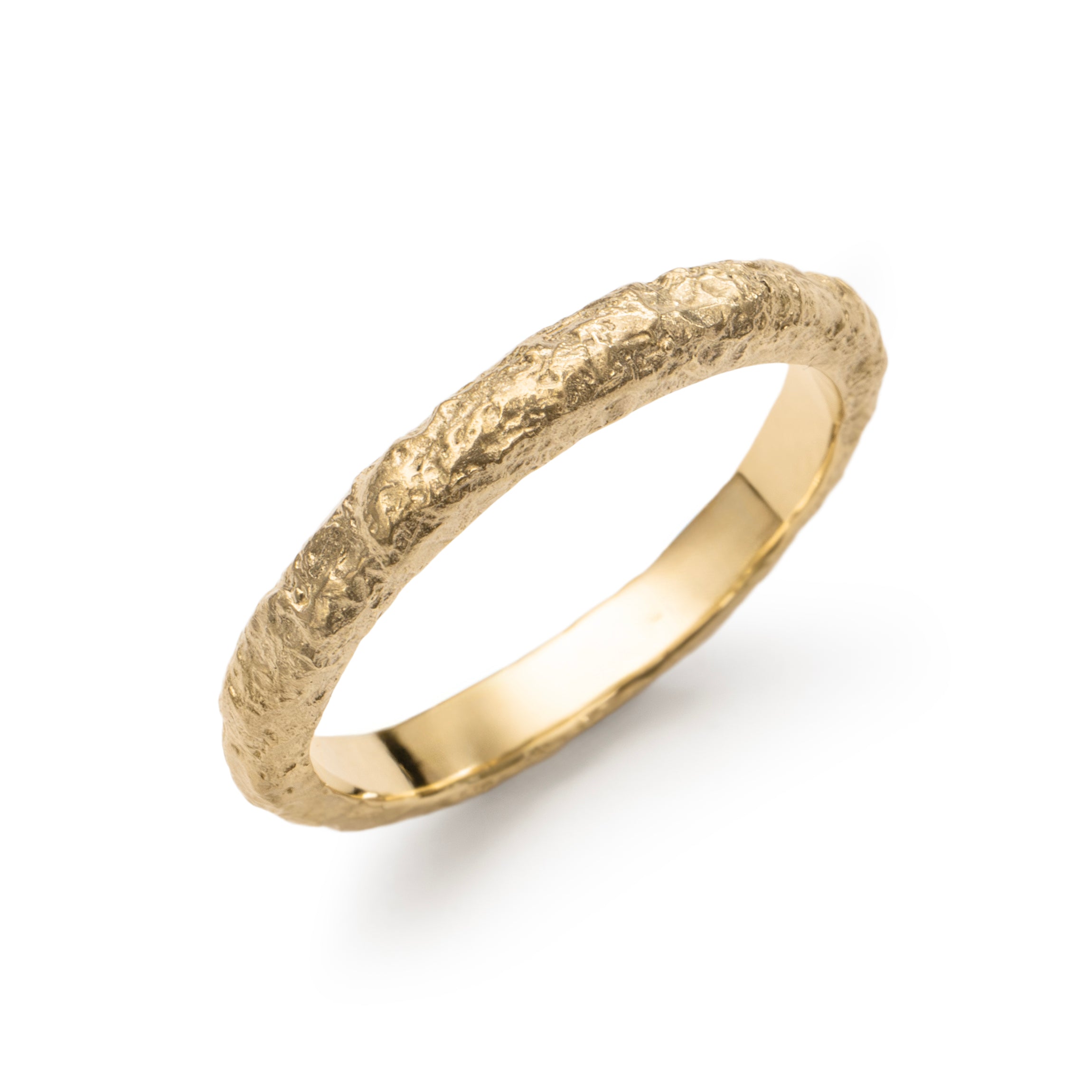 Textured yellow gold wedding band with eroded surface from an angled view.